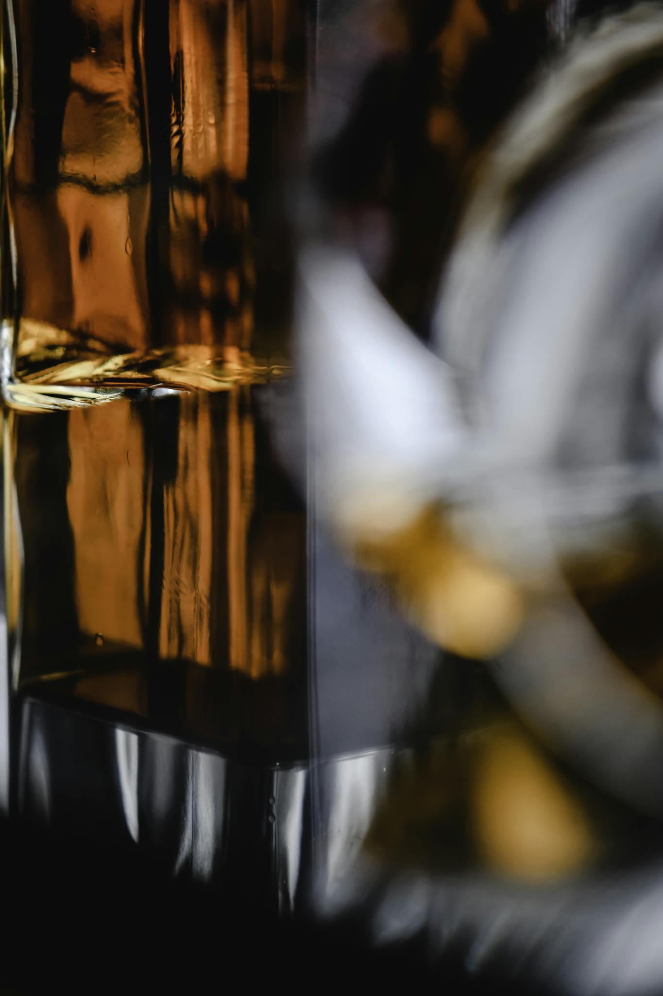 Close-up shot of a whiskey bottle showcasing amber hues and intricate reflections.